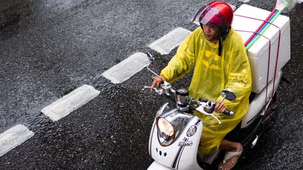 A rider wearing a raincoat while riding in wet weather.